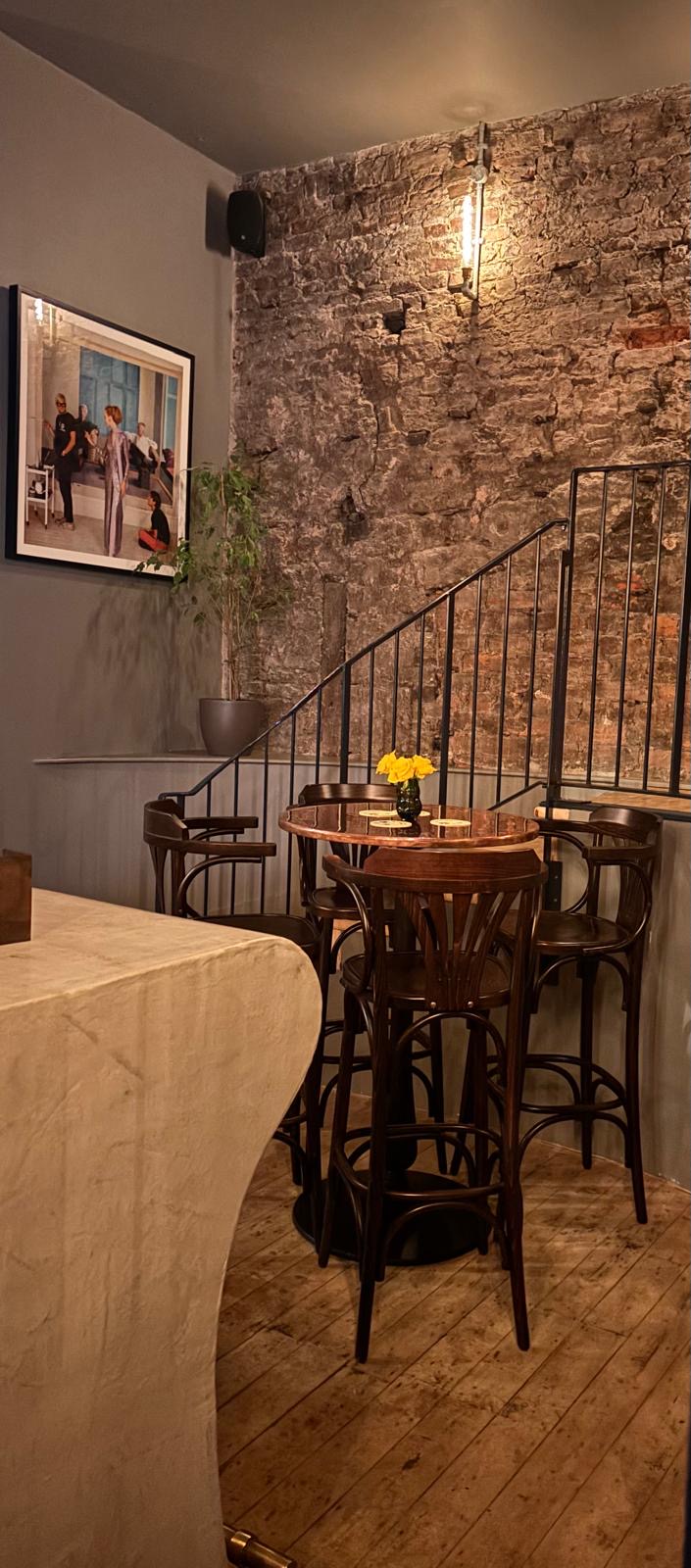The upstairs corner at The Britannia — stone wall, high tables, warm light