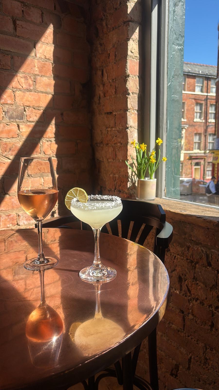 Two drinks on a copper table in the window at The Britannia